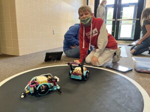 A student sets up LEGO Spikes on a mat