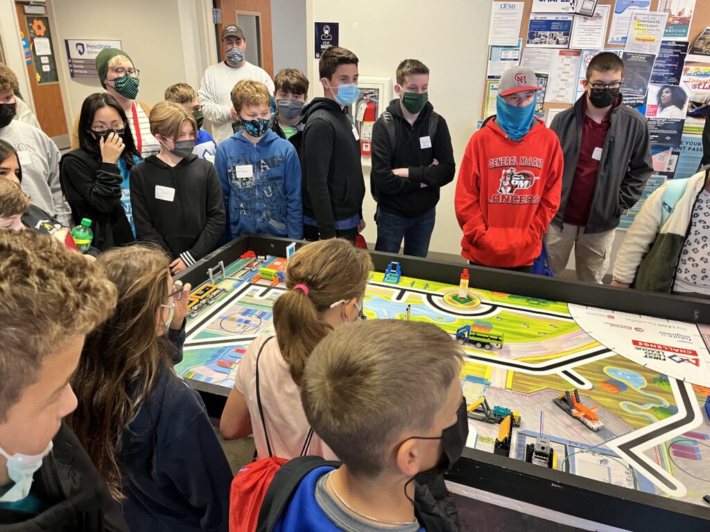 Students gather around the competition board