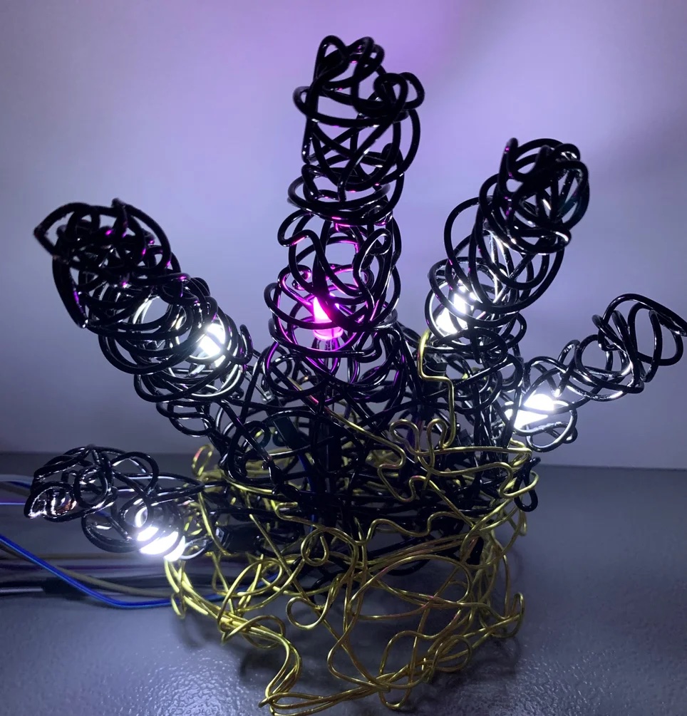 A student creation of a hand made of wires and various colored lights. 