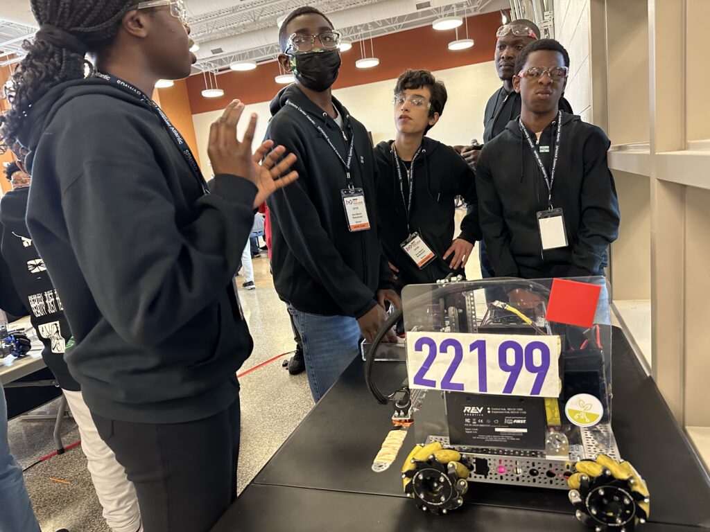 Team members stand around their robot. 