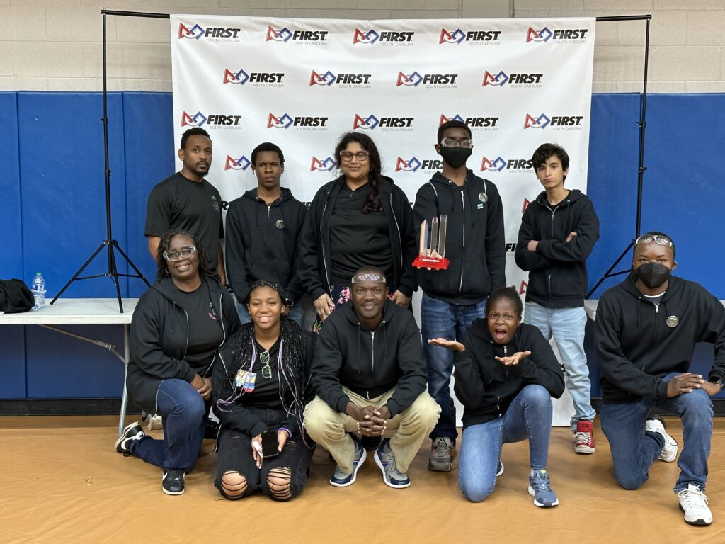 Team members pose for a picture at competition, holding their Motivate Award!