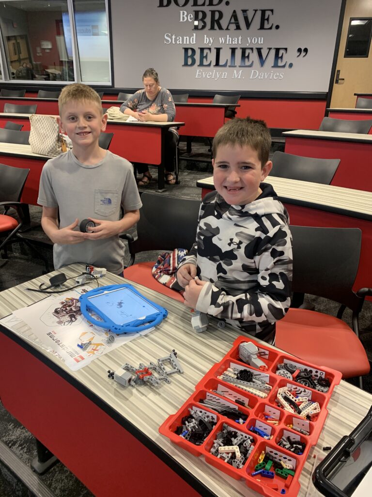 Students gather around an iPad and robot pieces at Texas Tech University. 