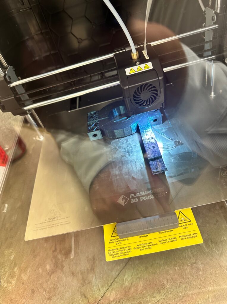 The 3D printer printing a student design. 