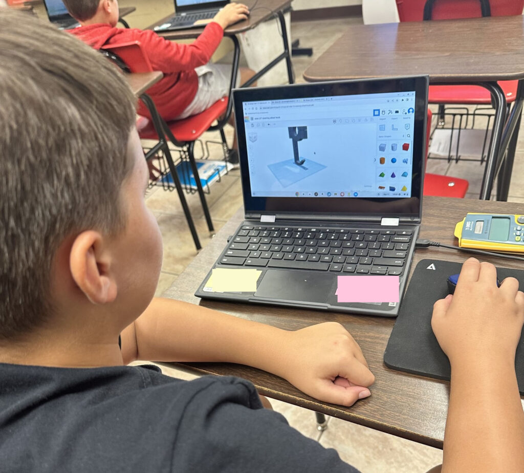 A student works with Tinkercad on a laptop to design a piece for the county fair. 