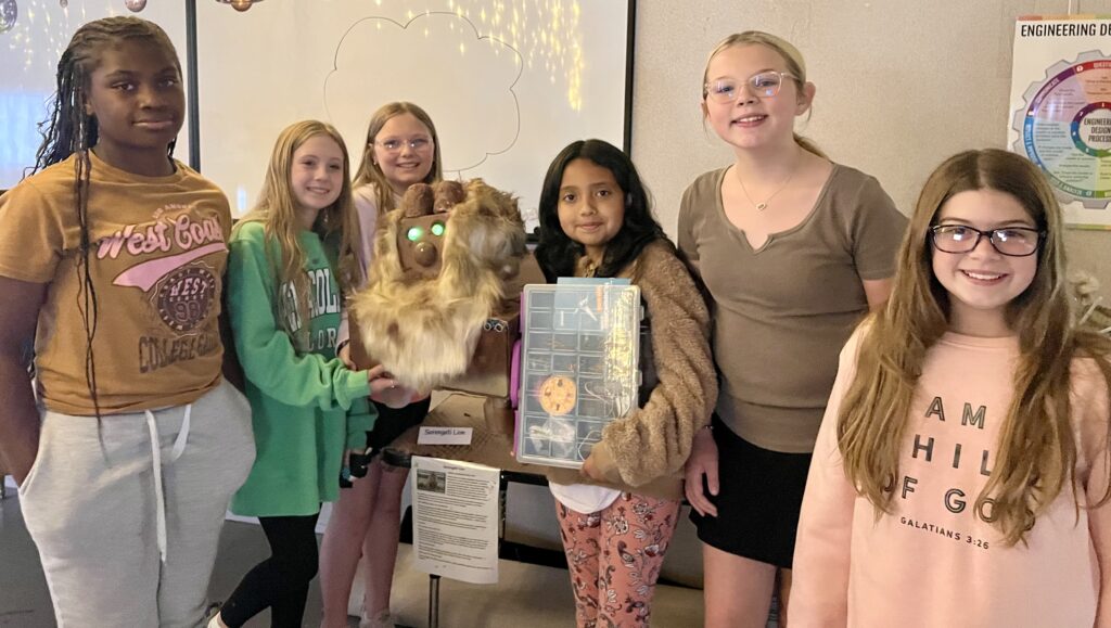 Six students pose with their animal creation and Hummingbird Robotics kit. 