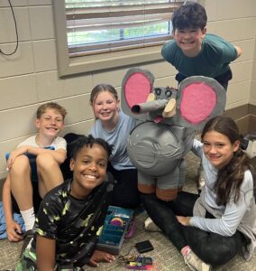 Five students with with their recyclable and robotics creation of an elephant.