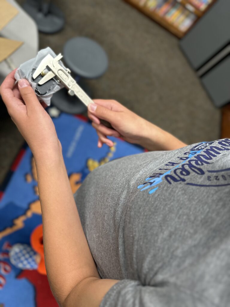 A student uses calipers while working through a 3D printing project. 