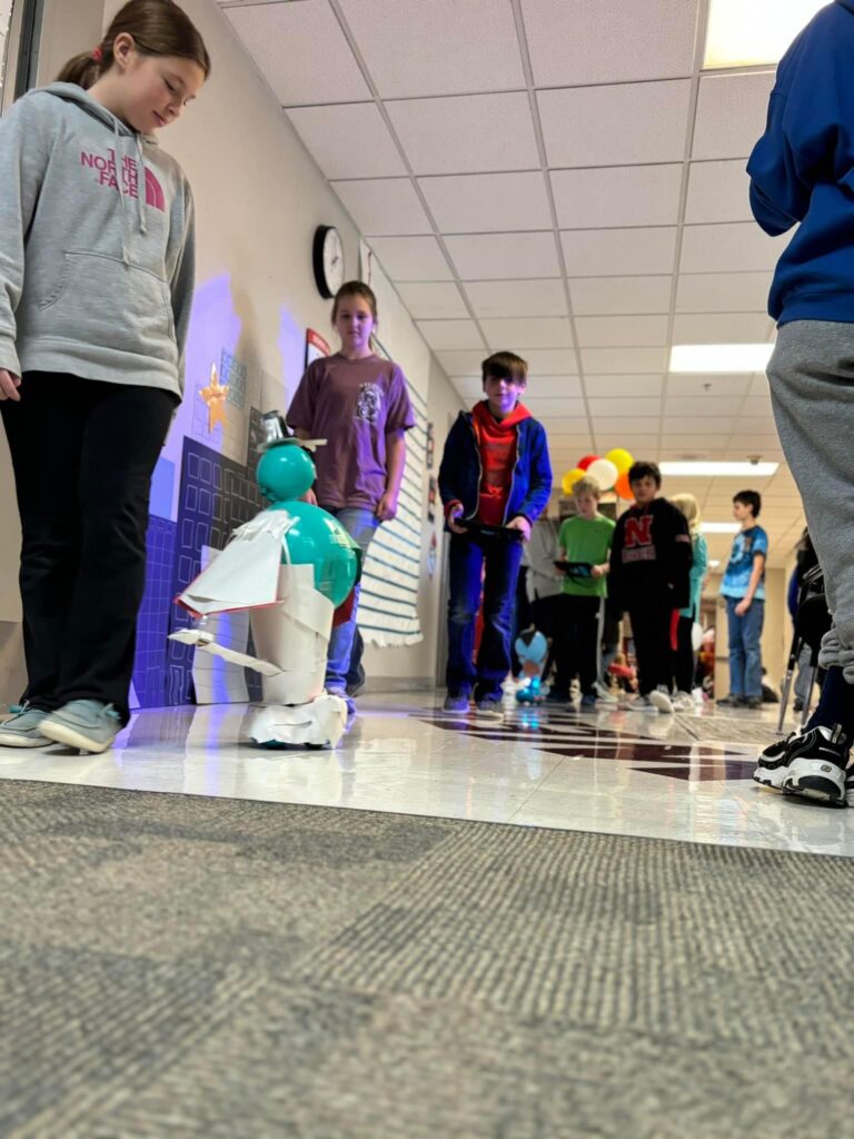 A balloon float atop a dash robot makes it way down the hallway parade route. 