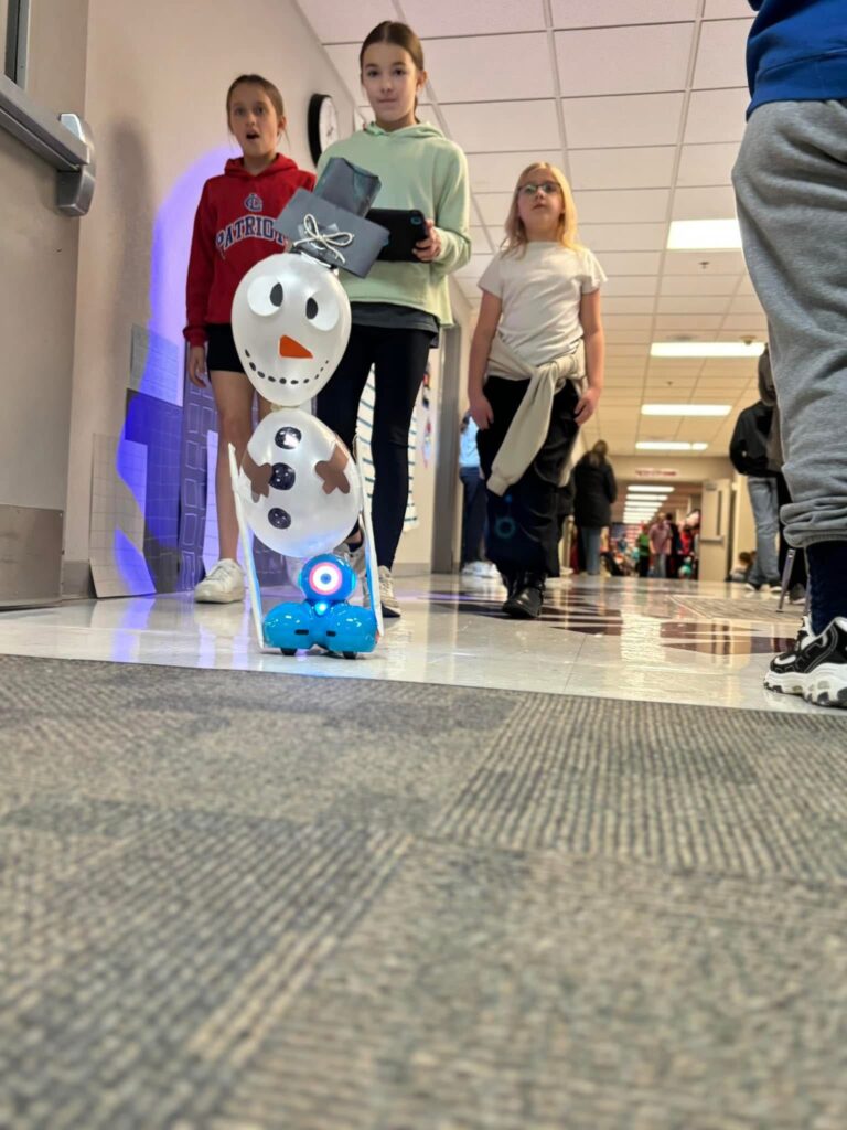 A snowman float atop a Dash robot makes it way down the hallway parade route. 