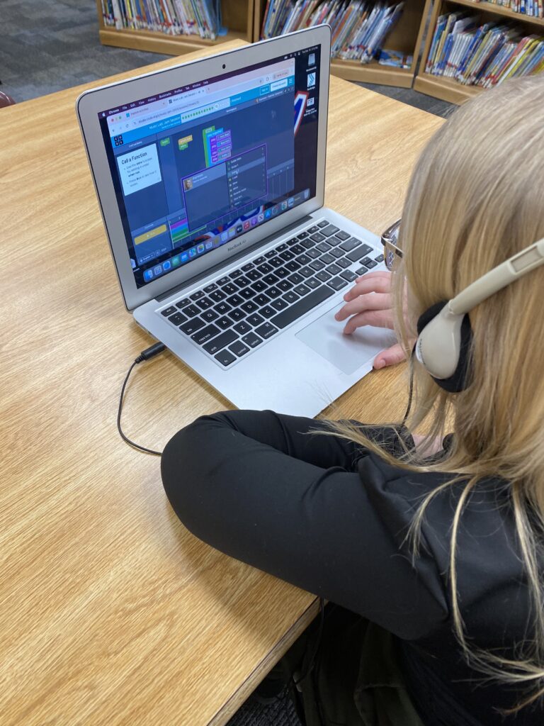 A student works on coding on a laptop. 