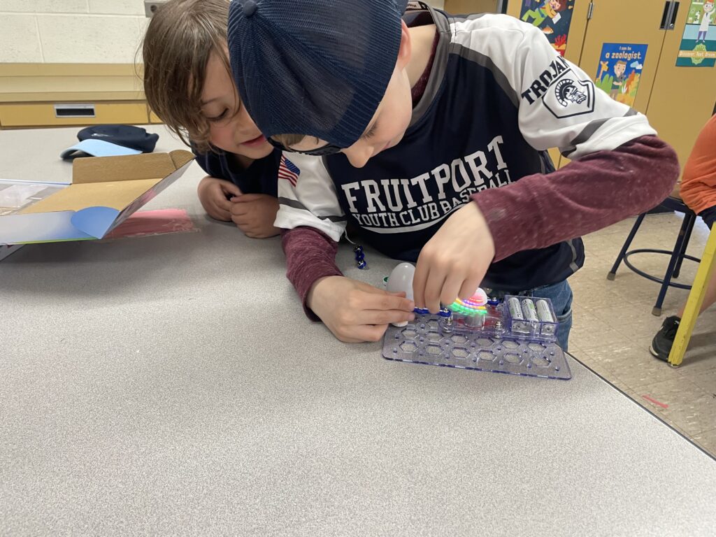 A student connects Snap Circuits as another student looks on. 