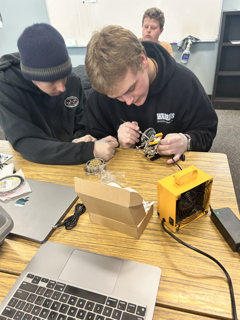 Robin Bolle's students work on assembling the CubeSat Emulator. 