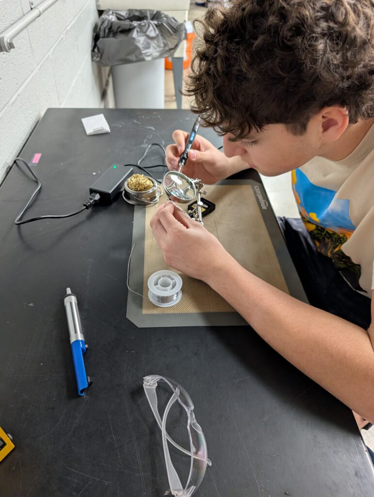 Breanne Williamson's student works on assembling the CubeSat Emulator. 