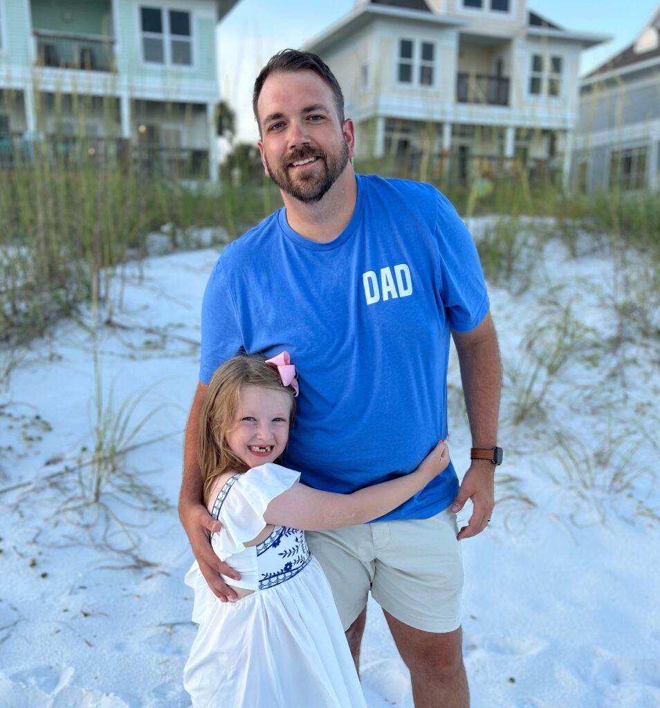 Wesley Martin poses on the beach with his daughter. 