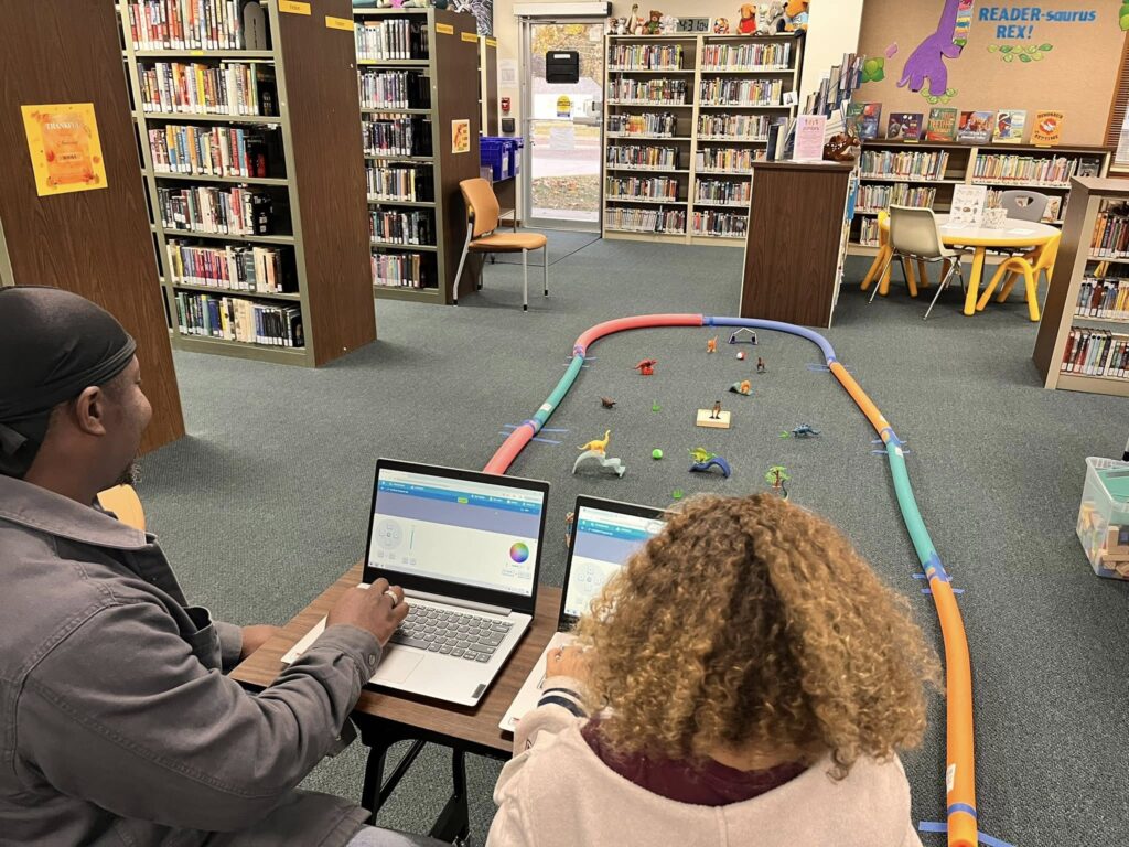 Patrons work on navigating Sphero minis through the Dinovember Maze Challenge.