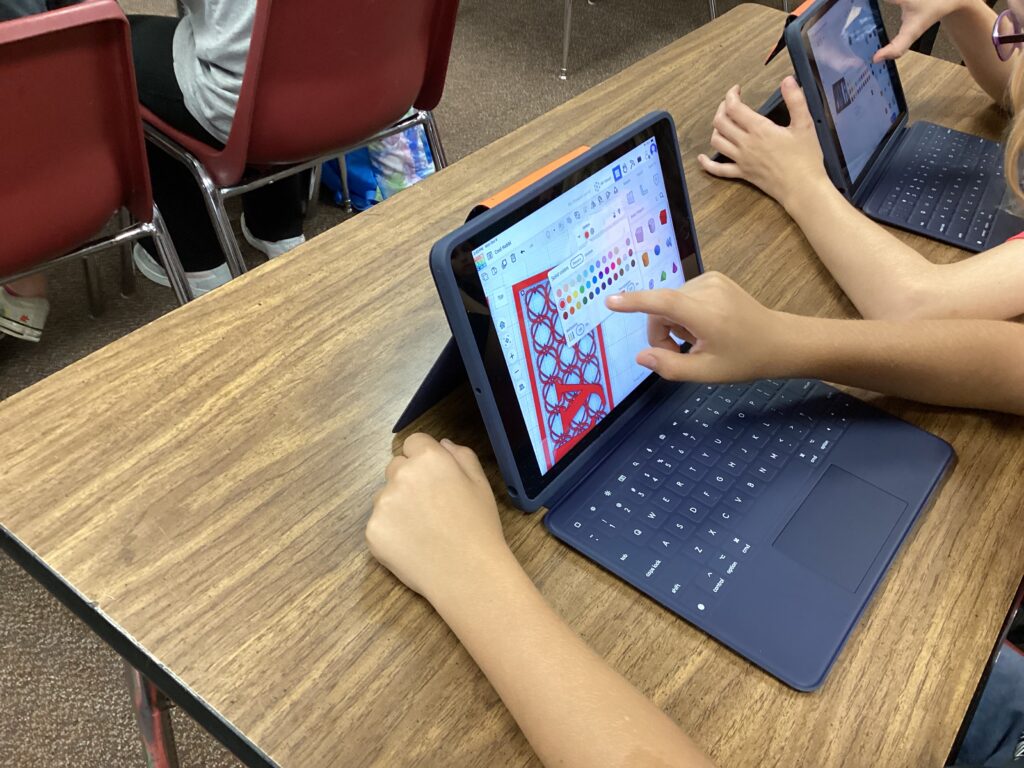 Students work on designs on tablets in the classoom.