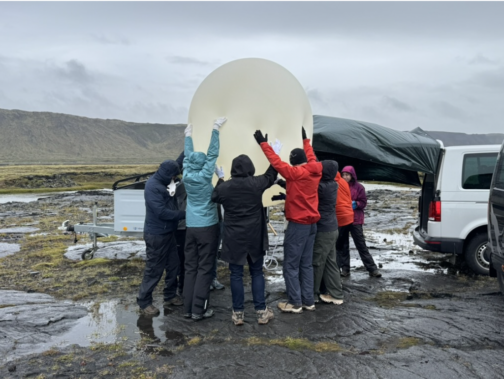 Individuals gather around their high-altitude balloon as they launch their experiments up into the stratosphere.