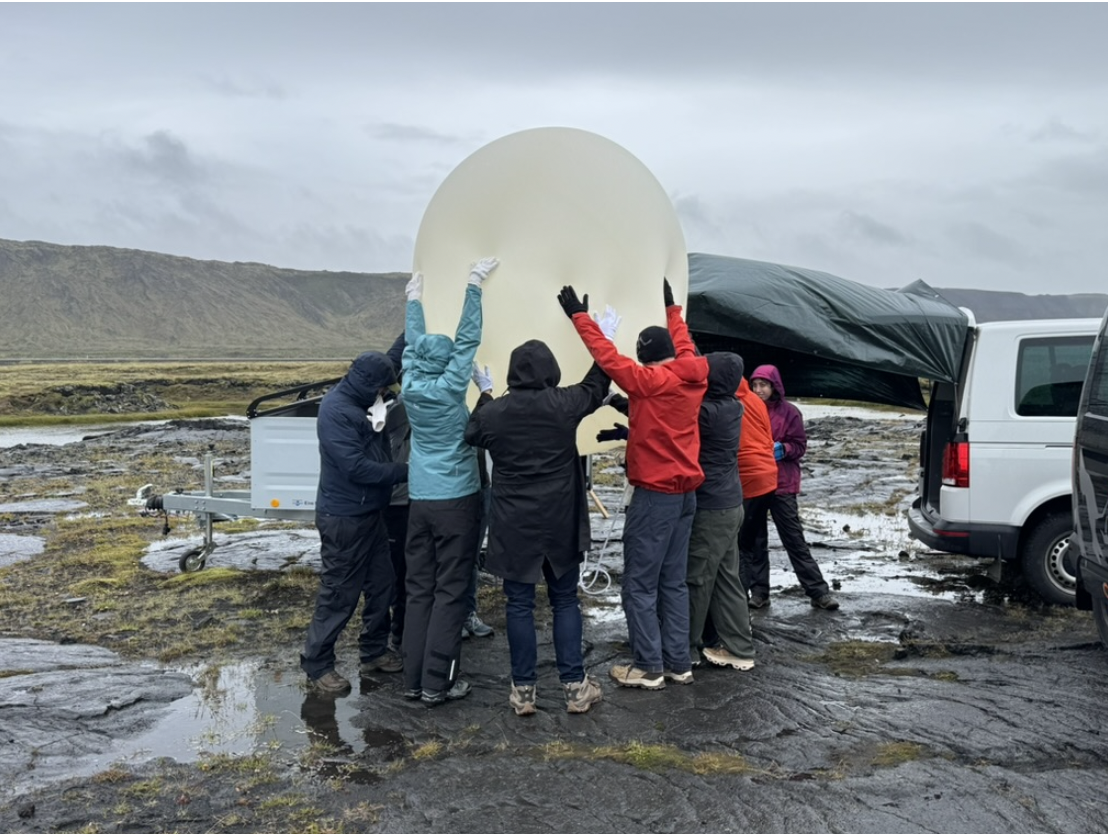 Individuals gather around their high-altitude balloon as they launch their experiments up into the stratosphere.